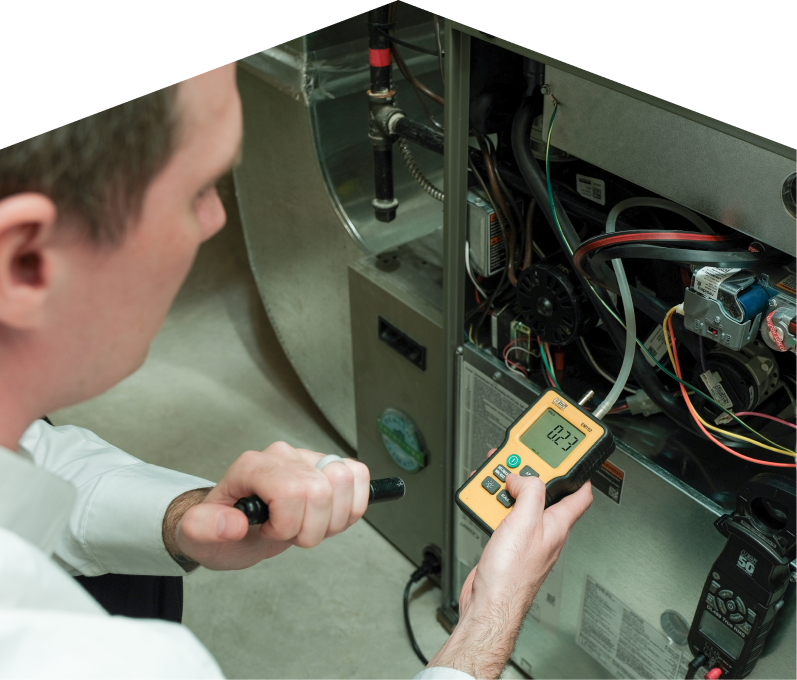 Romaniuk HVAC specialist performing furnace repair on a heating sy