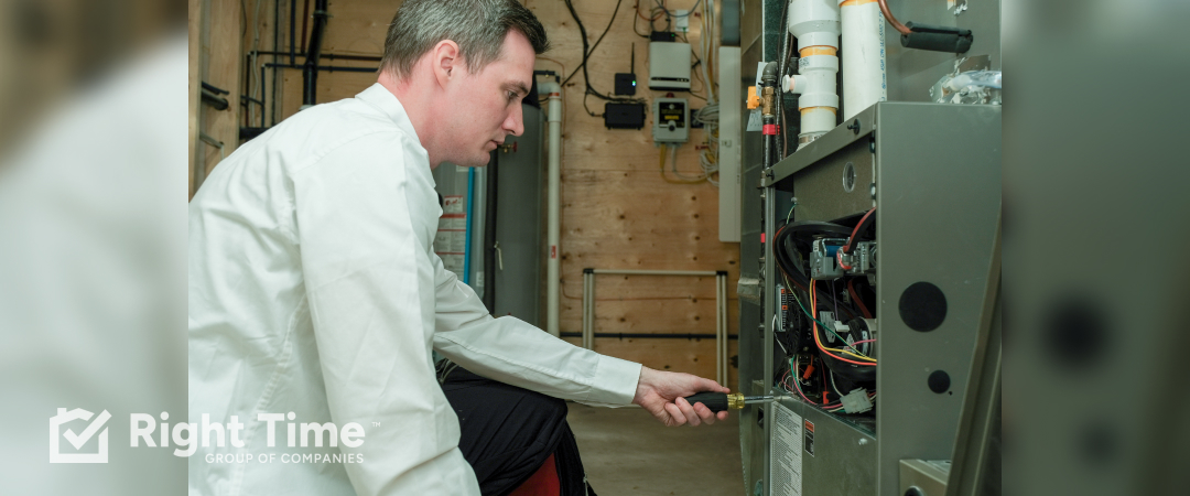 HVAC technician in white shirt examining furnace components with screwdriver during gas smell from furnace exhaust inspection in Edmonton home