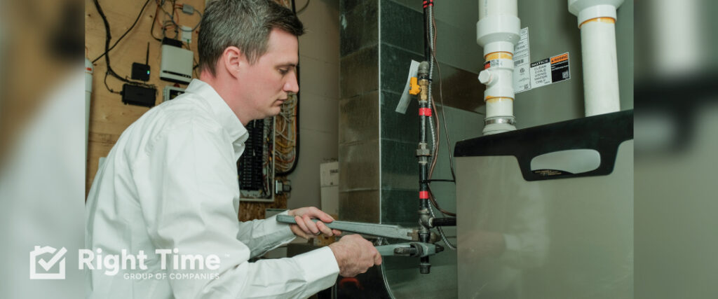 Technician inspecting a high-efficiency furnace vent system in Red Deer.