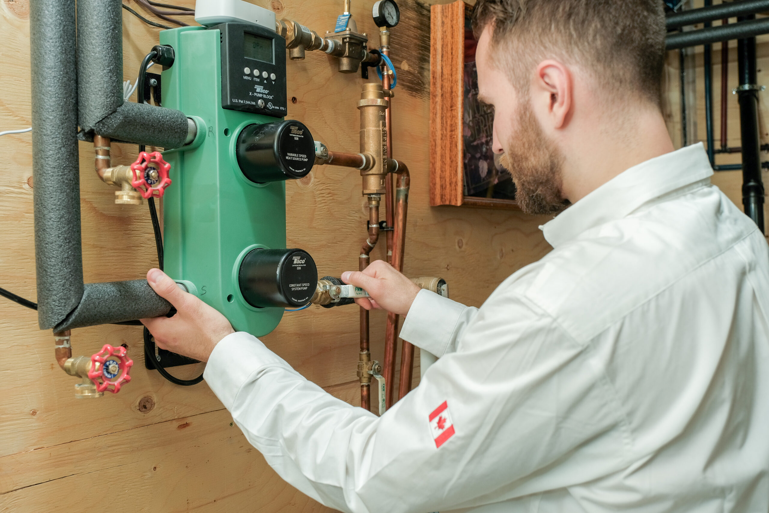 Technician inspecting a boiler circulation pump and controls in an Edmonton home.
